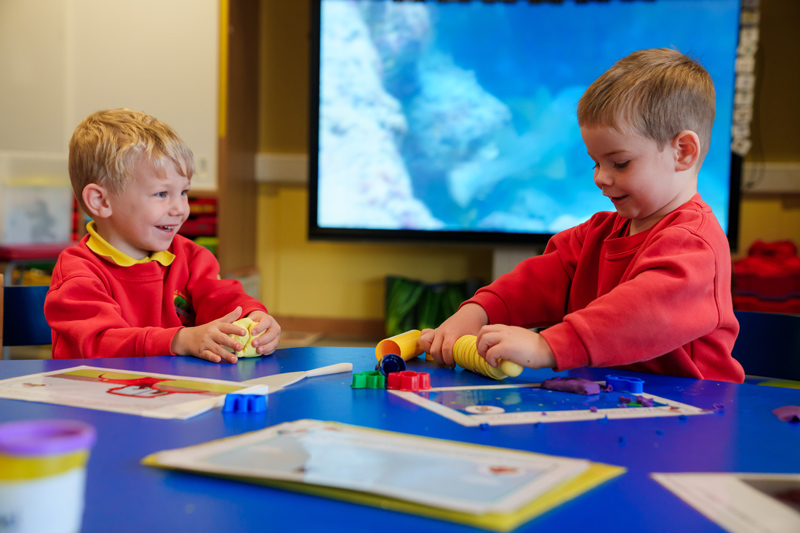 Two young children playing at a table
