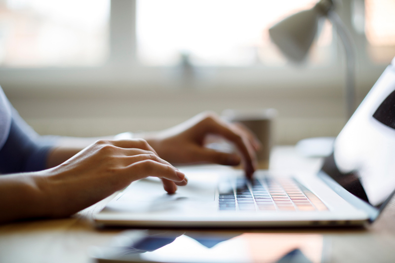 Hands at a laptop keyboard