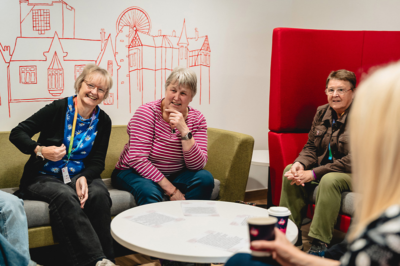 Adult Welsh learners sitting on sofas around a table