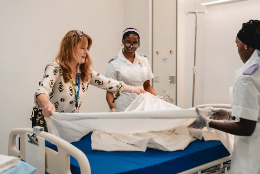Apprentice healthcare workers around a bed